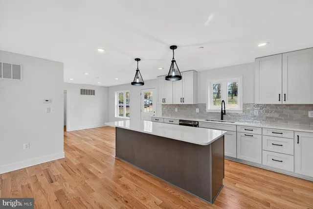 a kitchen with granite countertop a sink cabinets and wooden floor
