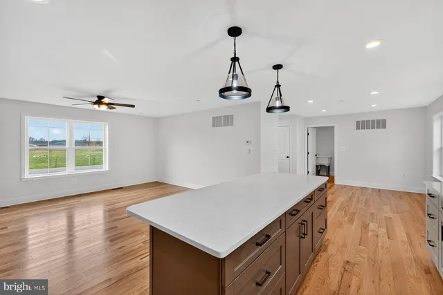 a kitchen that has a microwave a stove and wooden floor