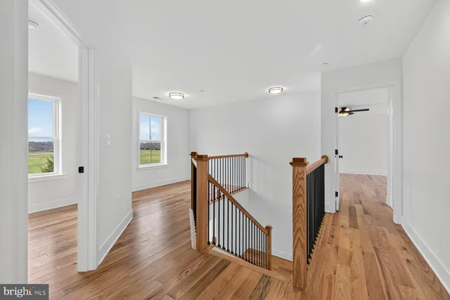a view of a hallway with wooden floor and staircase