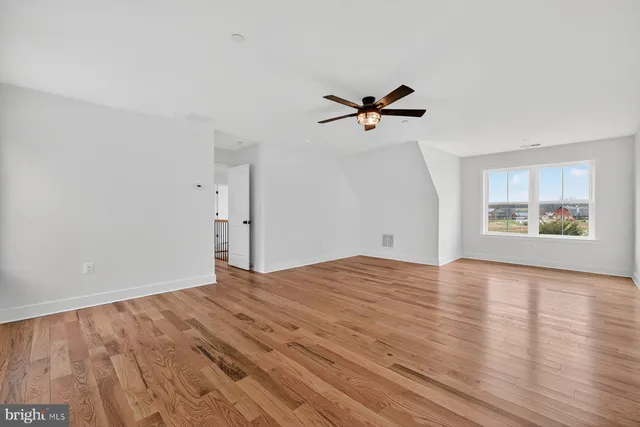 a view of room with a ceiling fan and hardwood floor