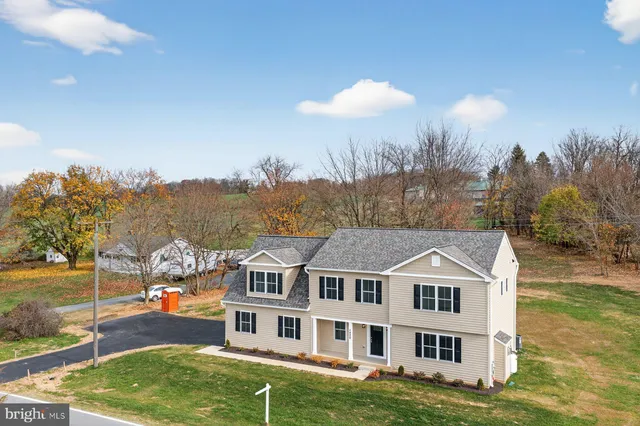 a view of a big house with a big yard and large trees