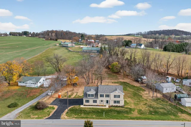 an aerial view of a house with a yard and lake view