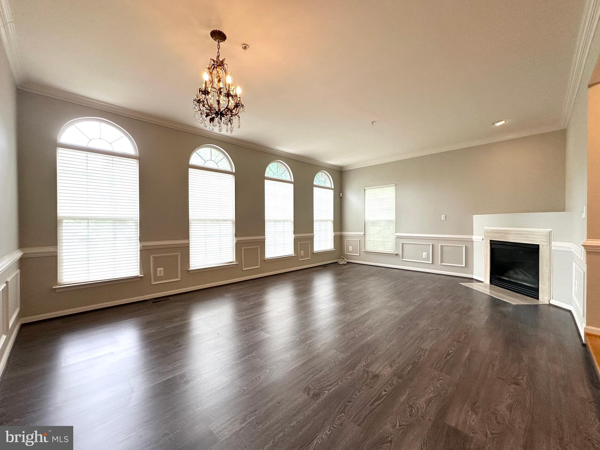 18100 Truffle Lane Boyds, MD 20841 - Photo 12 of 39 an empty room with wooden floor chandelier and windows