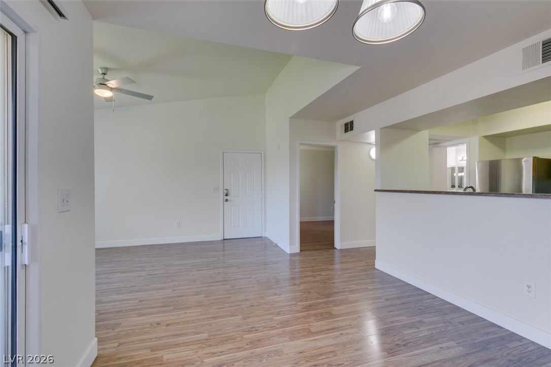 6650 West Warm Springs Road, Unit 2118 Las Vegas, NV 89118 - Photo 10 of 41 A living space seamlessly integrates with the kitchen, featuring wood-look flooring and a soaring ceiling.