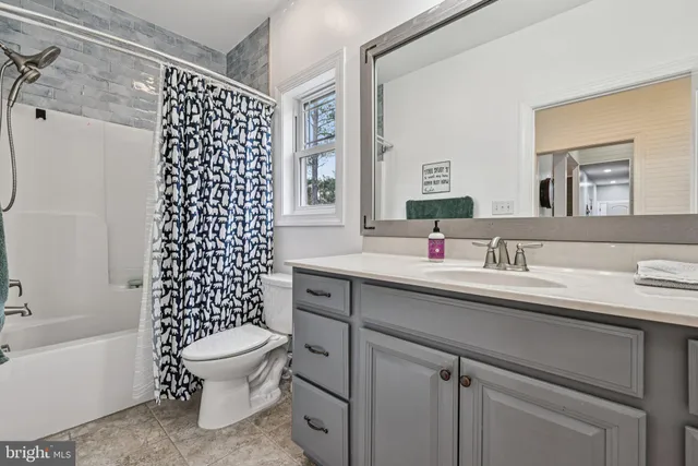 a bed sitting in a spacious bedroom next to a window