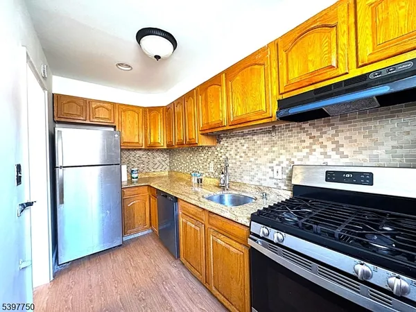 a kitchen with stainless steel appliances granite countertop a stove a refrigerator and a sink