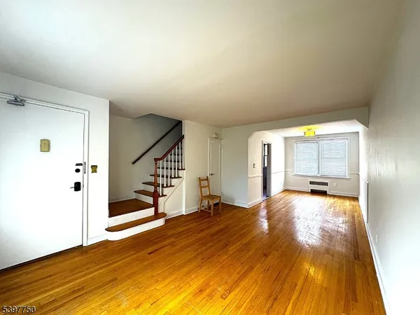 a view of a bedroom with wooden floor and sliding door