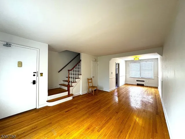 a view of a bedroom with wooden floor and sliding door
