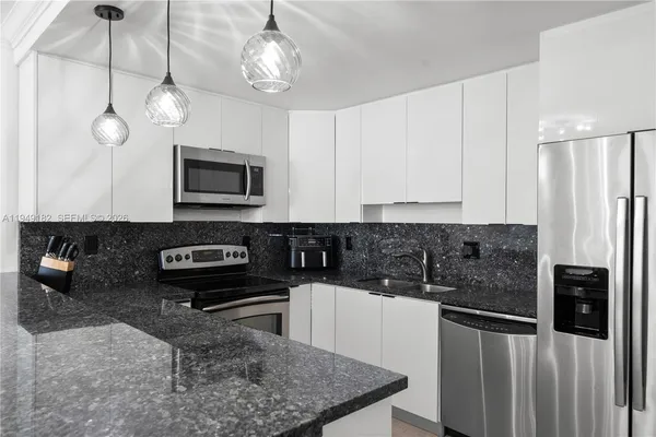 a kitchen with stainless steel appliances granite countertop a stove a microwave and a refrigerator