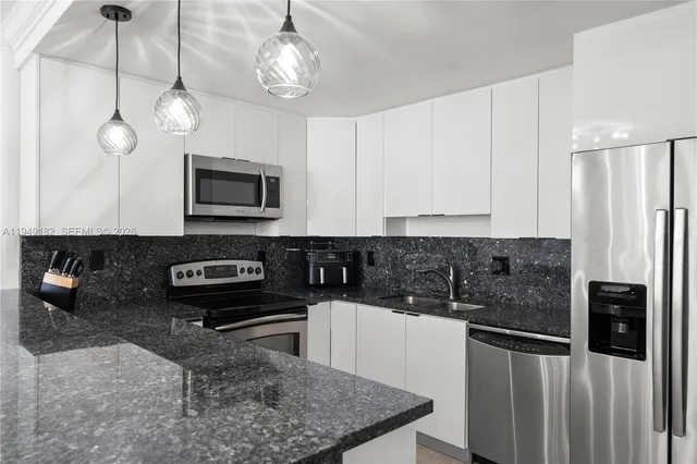 a kitchen with stainless steel appliances granite countertop a stove a microwave and a refrigerator
