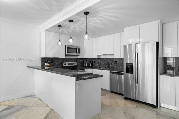 a kitchen with stainless steel appliances granite countertop a refrigerator a stove a sink and white cabinets