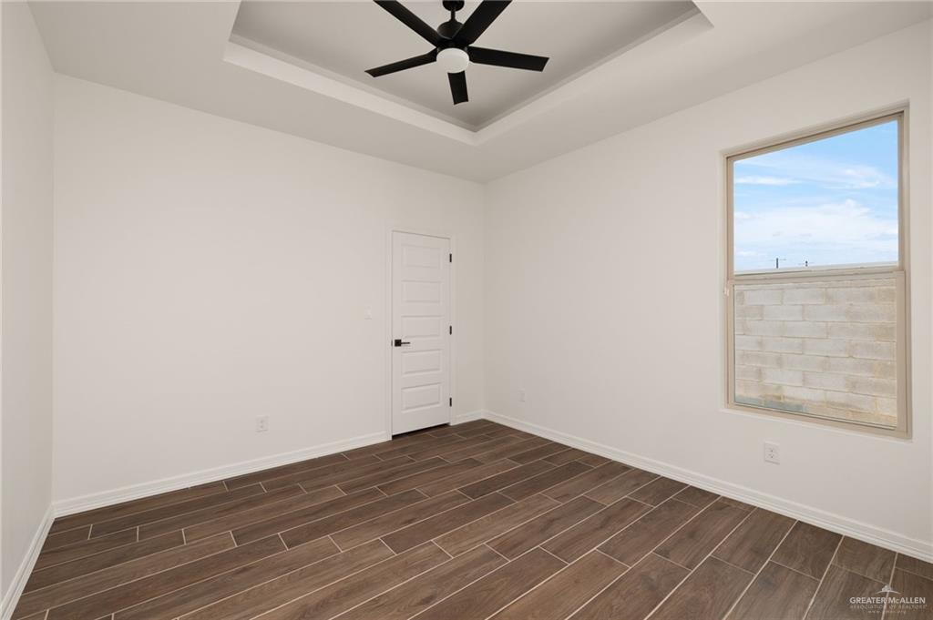4805 Baylor Avenue McAllen, TX 78504 - Photo 8 of 14 an empty room with wooden floor and windows
