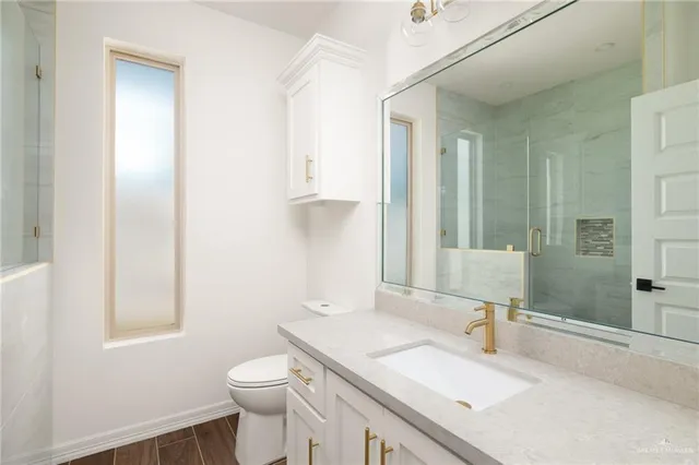 a bathroom with a sink toilet vanity and shower