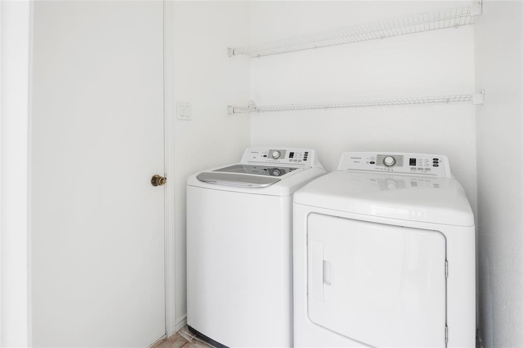 559 Raintree Circle Coppell, TX 75019 - Photo 18 of 40 Dedicated laundry area featuring a washer and dryer, white wire shelving, and a neutral wall finish