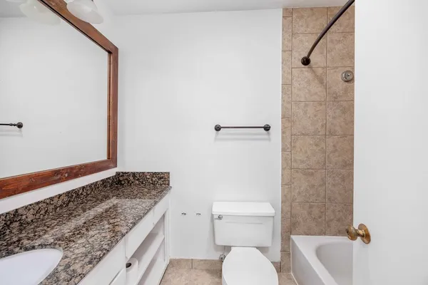 a bathroom with a granite countertop sink toilet and shower