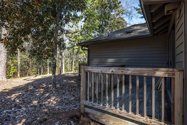 a view of backyard with wooden fence and large trees