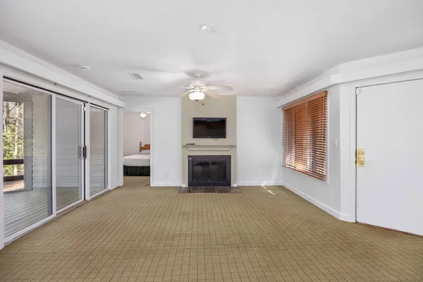 an empty room with windows fireplace and windows