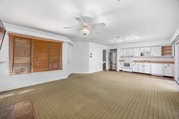 a view of an empty room with a window and cabinet
