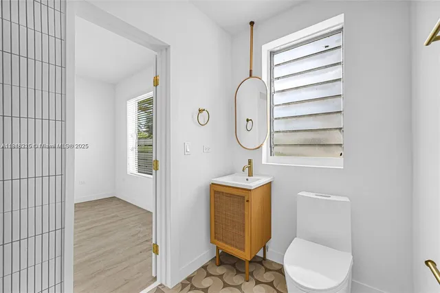 a bathroom with a toilet a sink and mirror