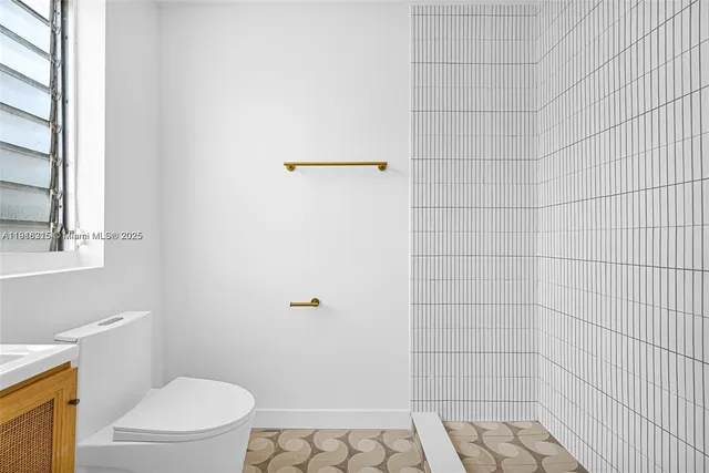 a white toilet sitting next to a shower