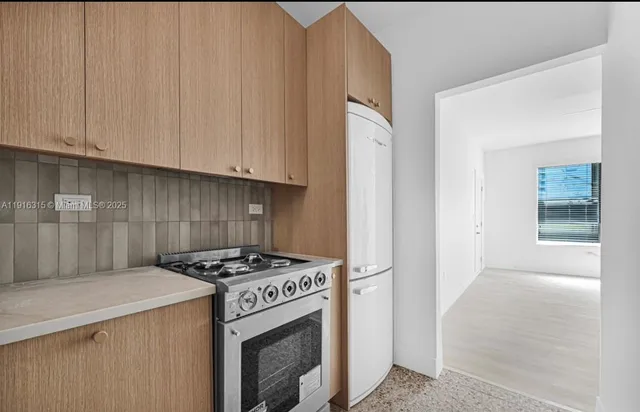 a kitchen with granite countertop a sink stove and cabinets