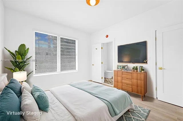 a bedroom with a bed and a flat screen tv