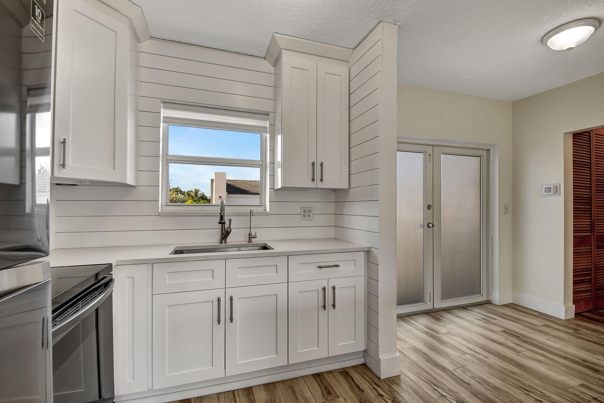 6520 North Ocean Boulevard, Unit 30 Ocean Ridge, FL 33435 - Photo 6 of 29 a kitchen with white cabinets and sink