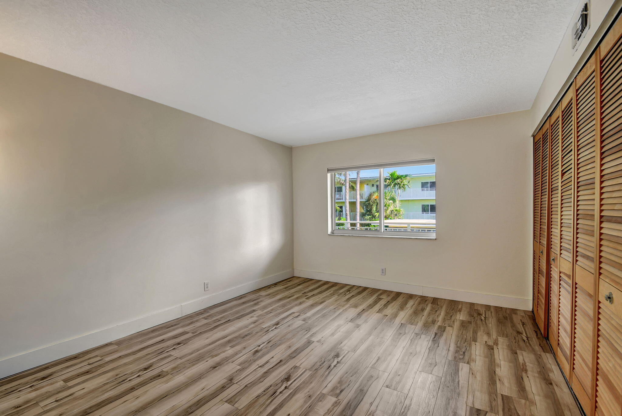 6520 North Ocean Boulevard, Unit 30 Ocean Ridge, FL 33435 - Photo 9 of 29 wooden floor in an empty room with a window