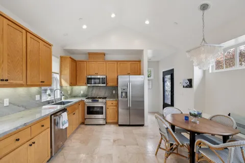 a kitchen with stainless steel appliances granite countertop a sink refrigerator and cabinets