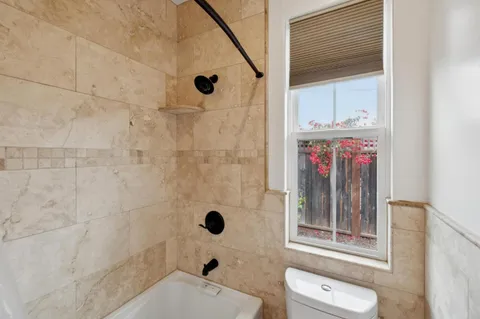 a bathroom with a granite countertop toilet sink and mirror