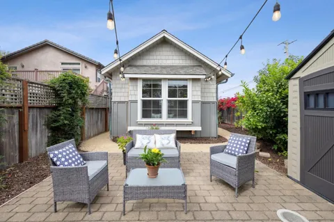 a view of a house with backyard and sitting area