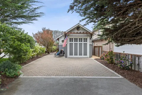 a front view of a house with a yard and trees