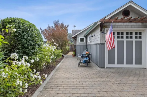 a view of a house with a yard and a bench