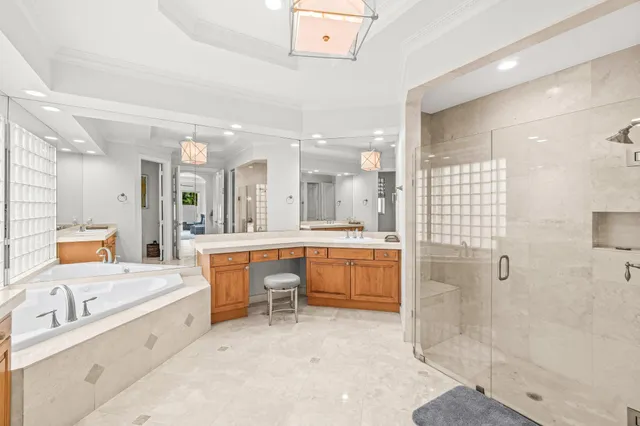 a bedroom with a bed a chair and potted plant with the dresser