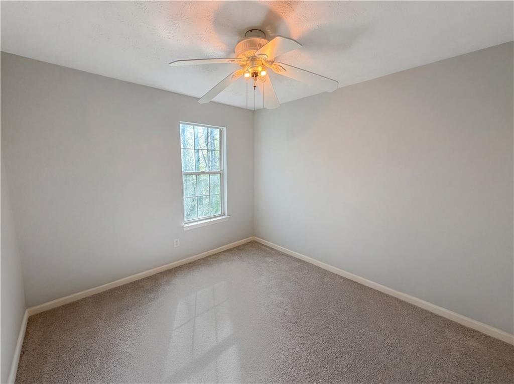 403 Clearstream Lane Austell, GA 30168 - Photo 14 of 25 an empty room with a window and a chandelier fan