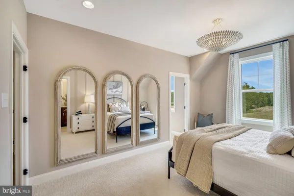 a spacious bedroom with a bed and a chandelier
