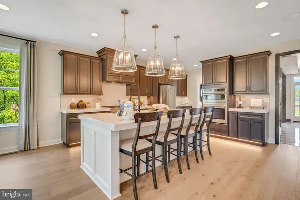 a kitchen with kitchen island granite countertop wooden cabinets and stainless steel appliances
