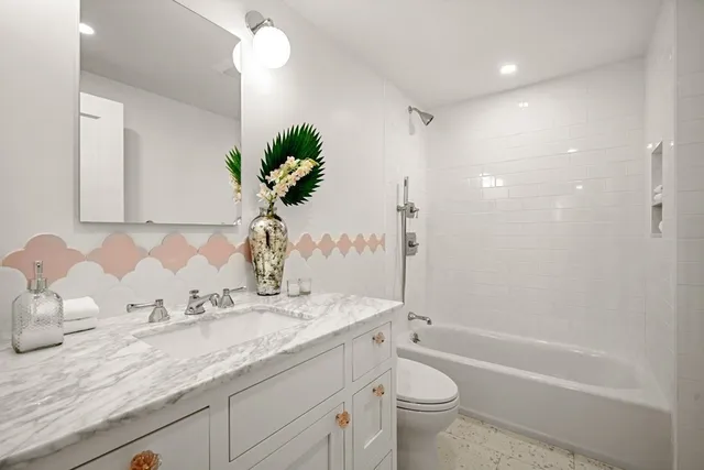 a bathroom with a granite countertop sink a toilet and bathtub