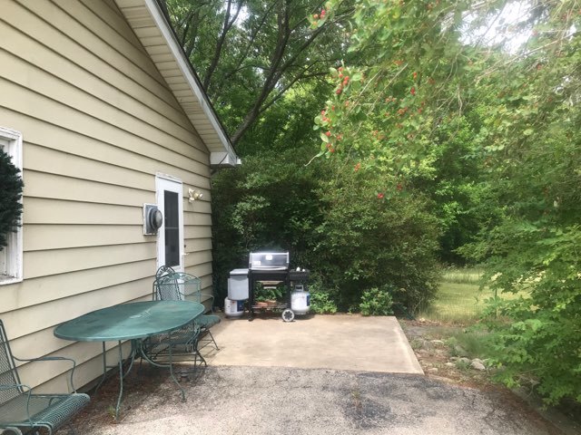 9-n087 Corron Road Elgin, IL 60124 - Photo 8 of 12 a view of a patio with table and chairs with wooden fence and plants