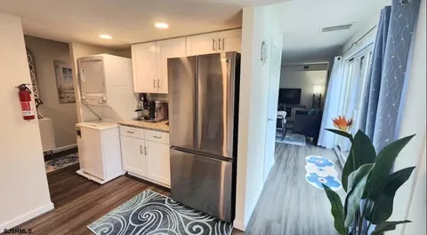 a kitchen with stainless steel appliances a refrigerator and wooden floor