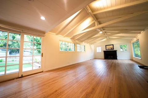 a view of a room with wooden floor and windows