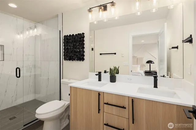 a bathroom with a double vanity sink toilet and shower