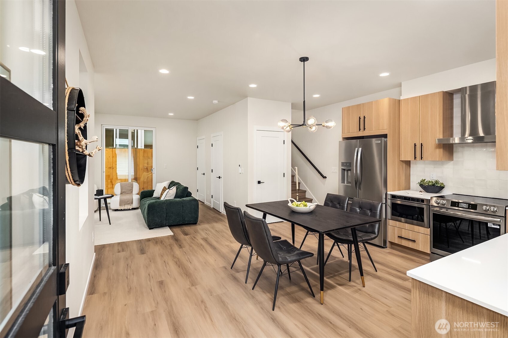 1514 Northwest 63rd Street, Unit B Seattle, WA 98107 - Photo 3 of 20 a kitchen with stainless steel appliances granite countertop a stove refrigerator a dining table and chairs with wooden floor