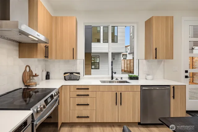 a kitchen with stainless steel appliances granite countertop a sink stove and cabinets