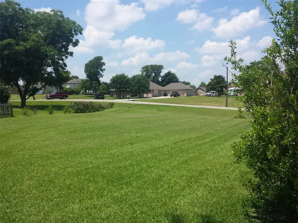 a view of a green field with wooden fence