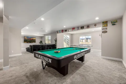 a room with pool table and windows