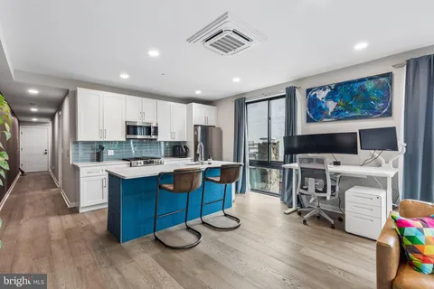 a kitchen with stainless steel appliances granite countertop a stove a refrigerator and a white cabinets