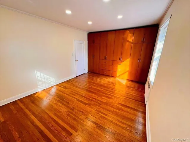 an empty room with wooden floor and sliding door