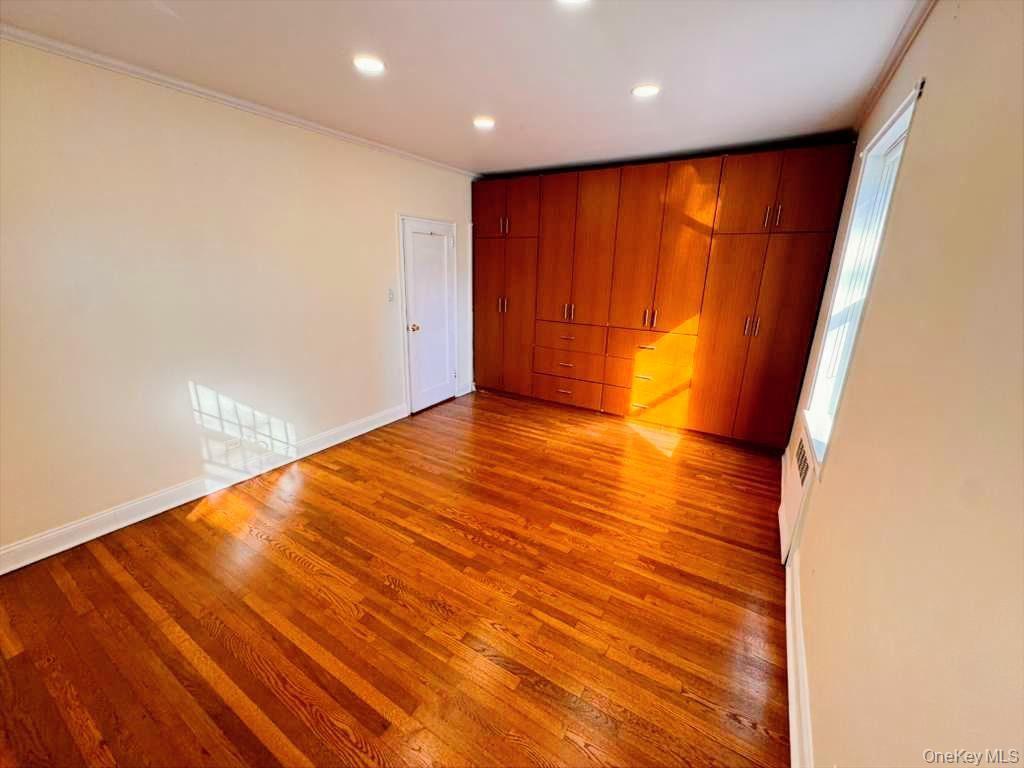 63-60 102nd Street, Unit A7 Queens, NY 11374 - Photo 13 of 15 an empty room with wooden floor and sliding door