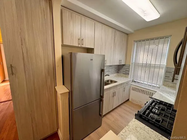 a kitchen with a refrigerator sink and cabinets